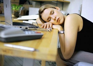 Femme endormie, la tête posée sur un bureau